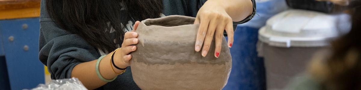 student working on her ceramic pot